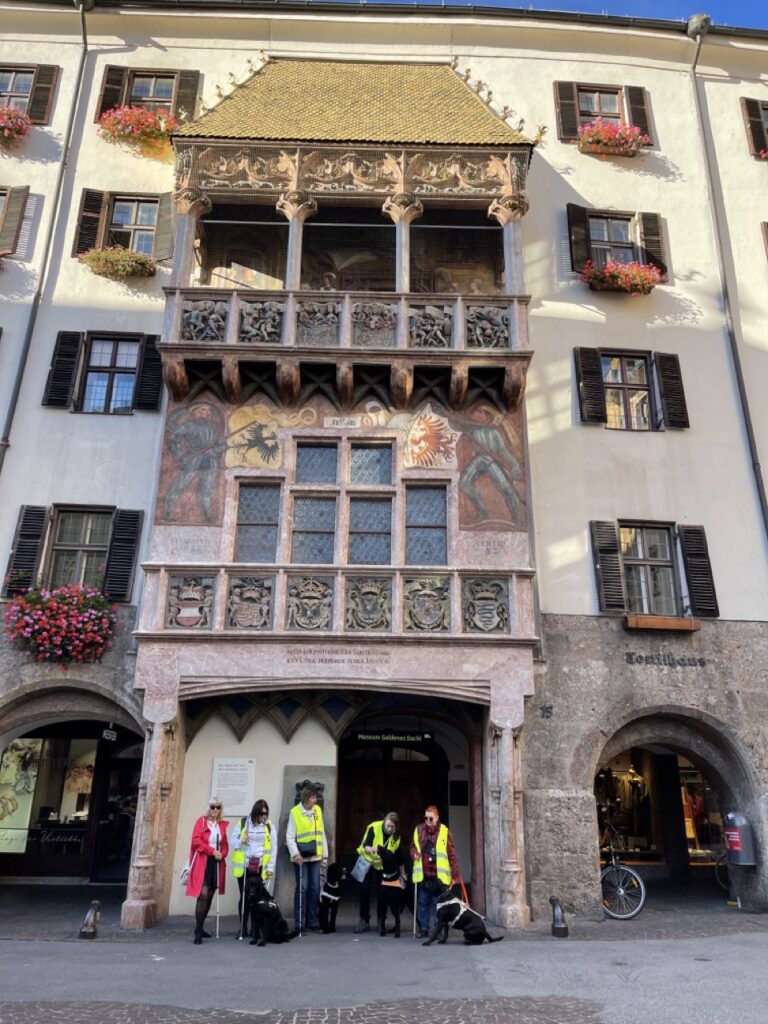 5 Menschen, 4 Führhunde sind vor dem Goldenen Dachl von Innsbruck